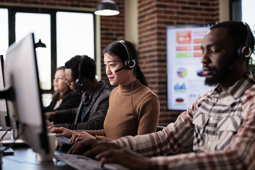 Asian operator working as sales assistant at call center service, helping clients at customer care support. Telecommunication consultant using telemarketing helpline at reception desk.